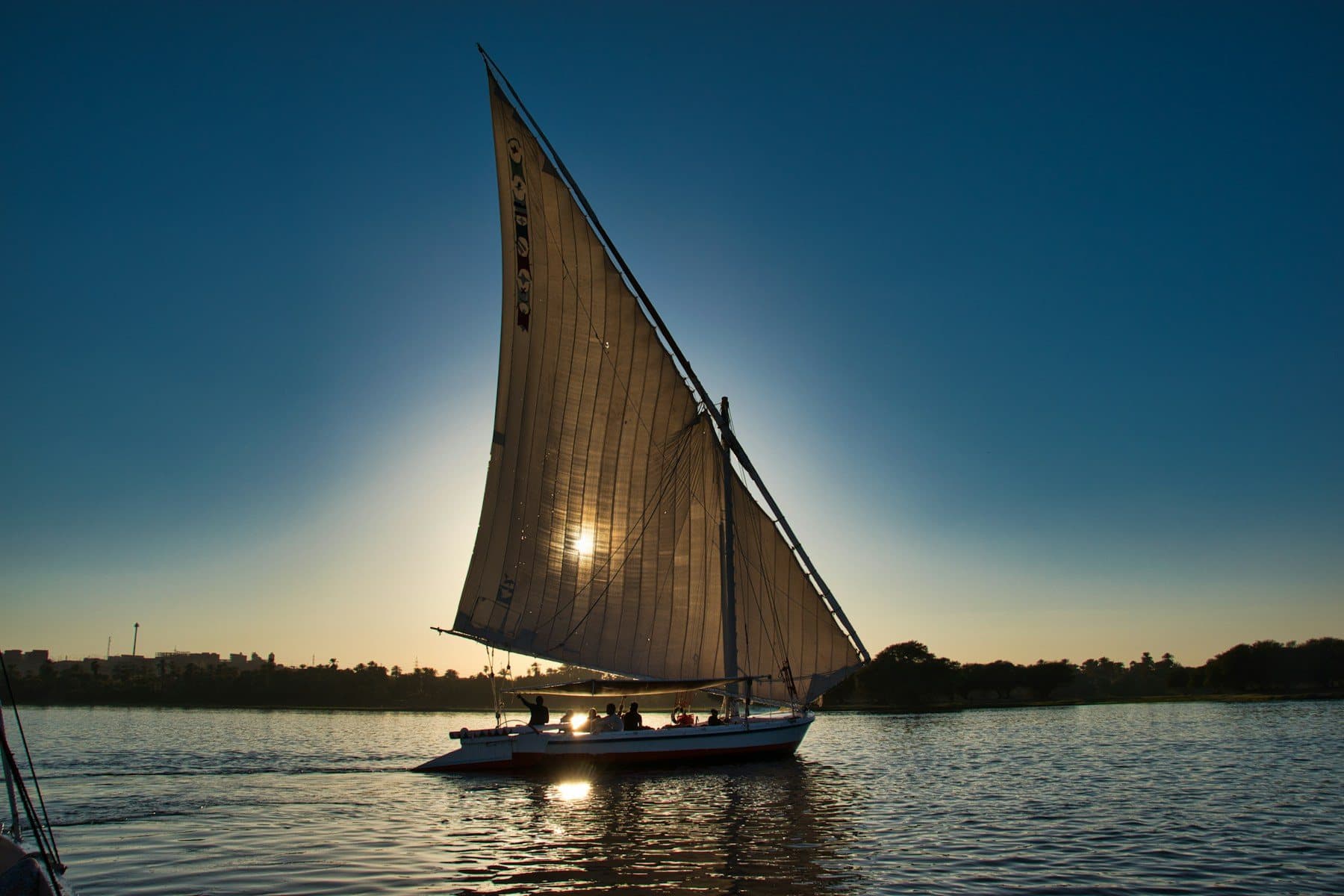 Felucca sailboat backlit by the sun on the Nile at Aswan