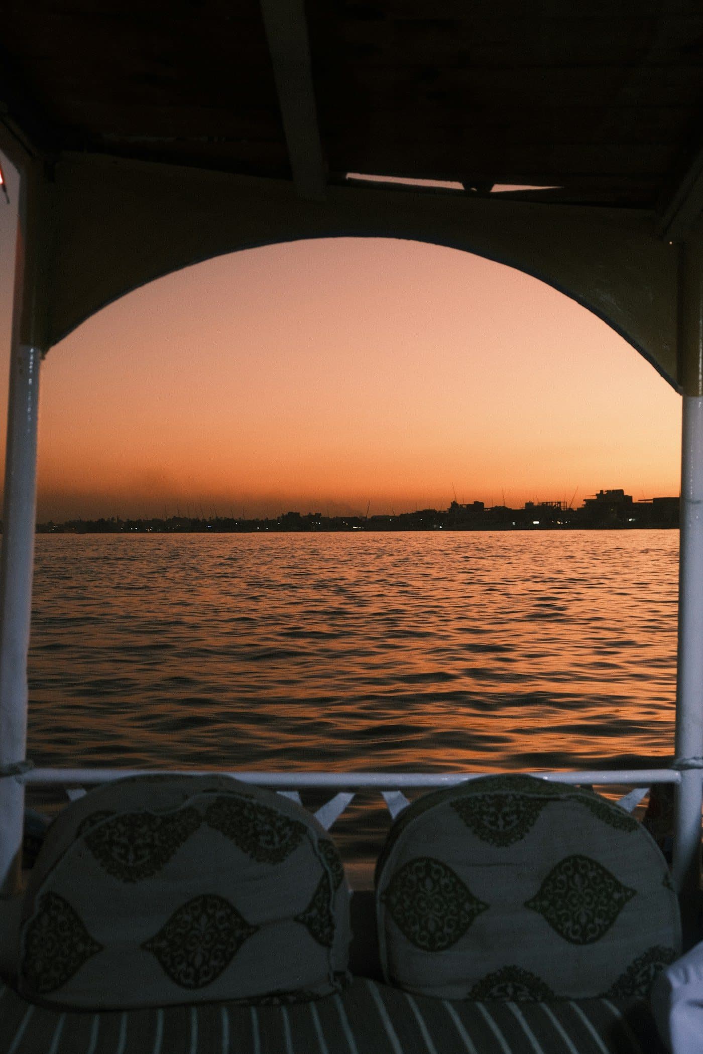 Sunset over the Nile seen through the arched window of a cruise ship