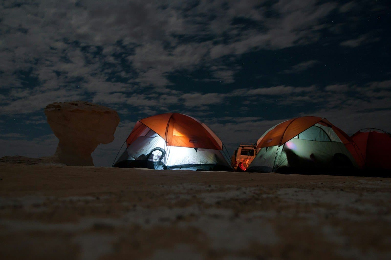 Tents lit from within at a night camp in the White Desert
