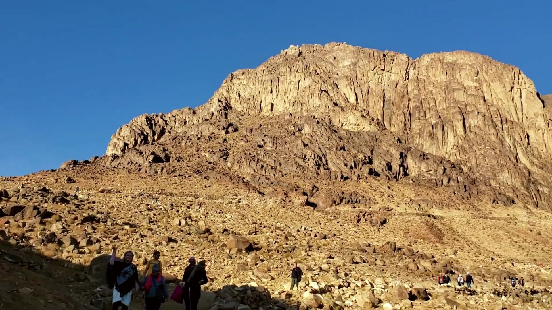 Two travellers watching the sunrise from the summit of Mount Sinai