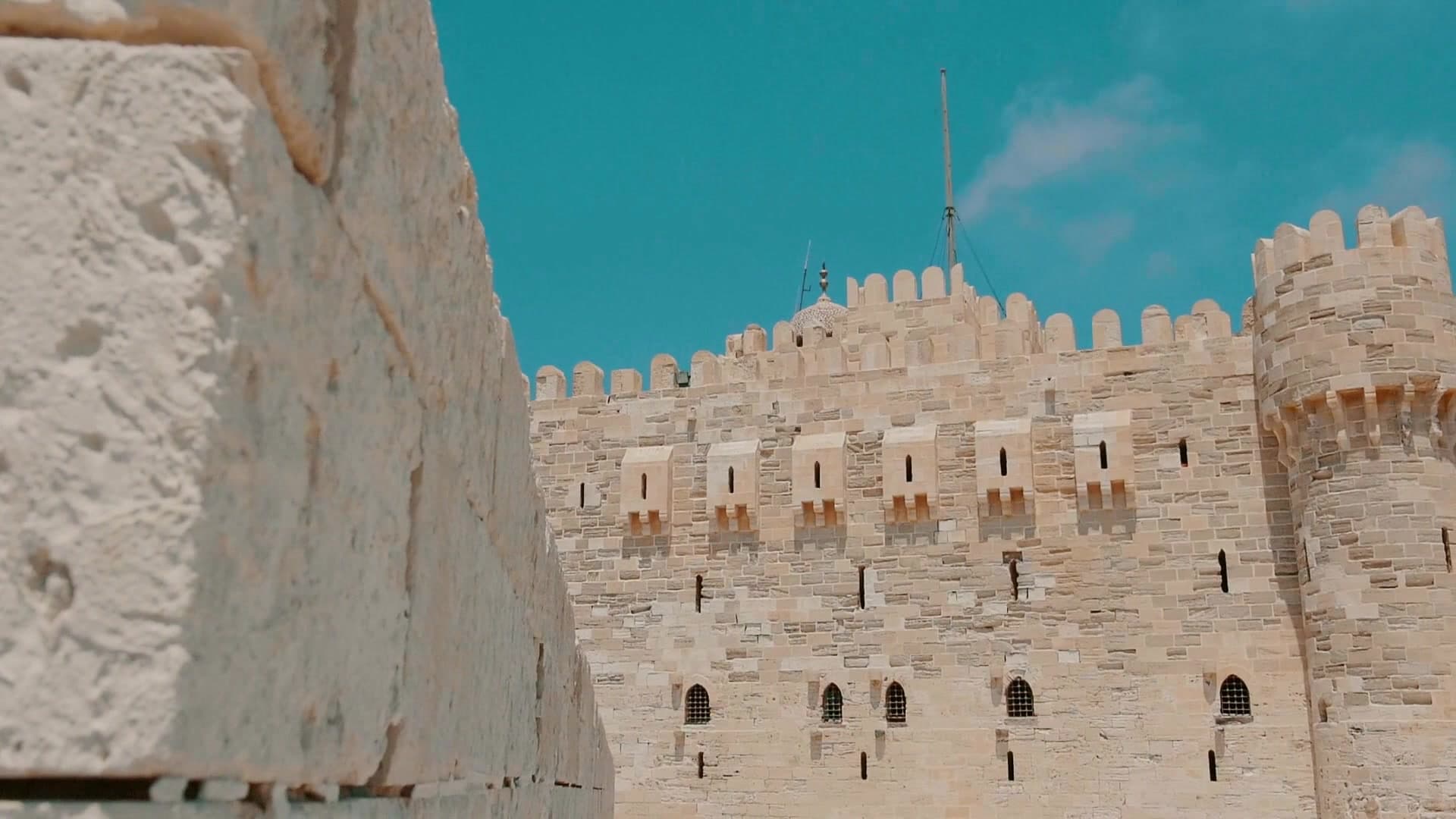 Citadel of Qaitbay glowing at sunset across Alexandria's eastern harbour