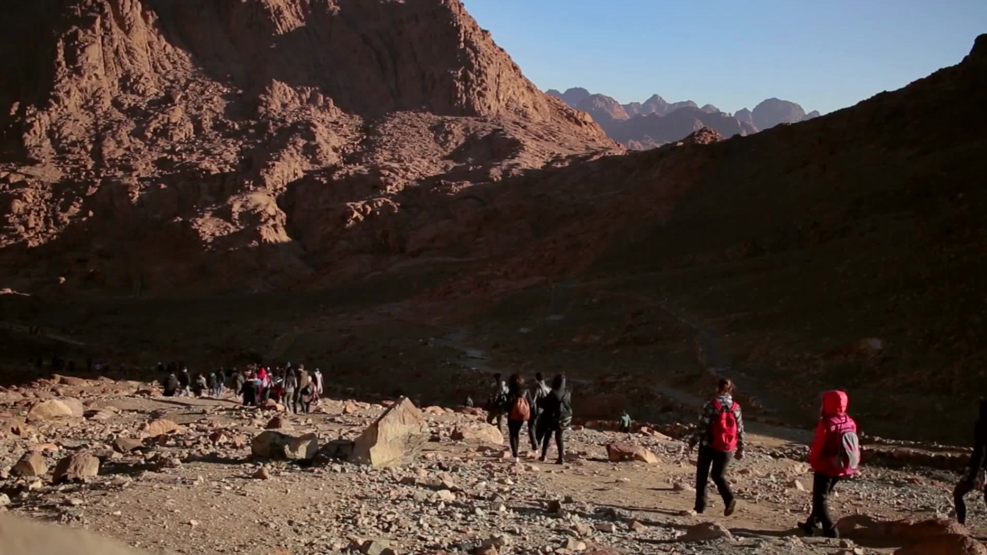 Two pilgrims watching sunrise from the summit of Mount Sinai