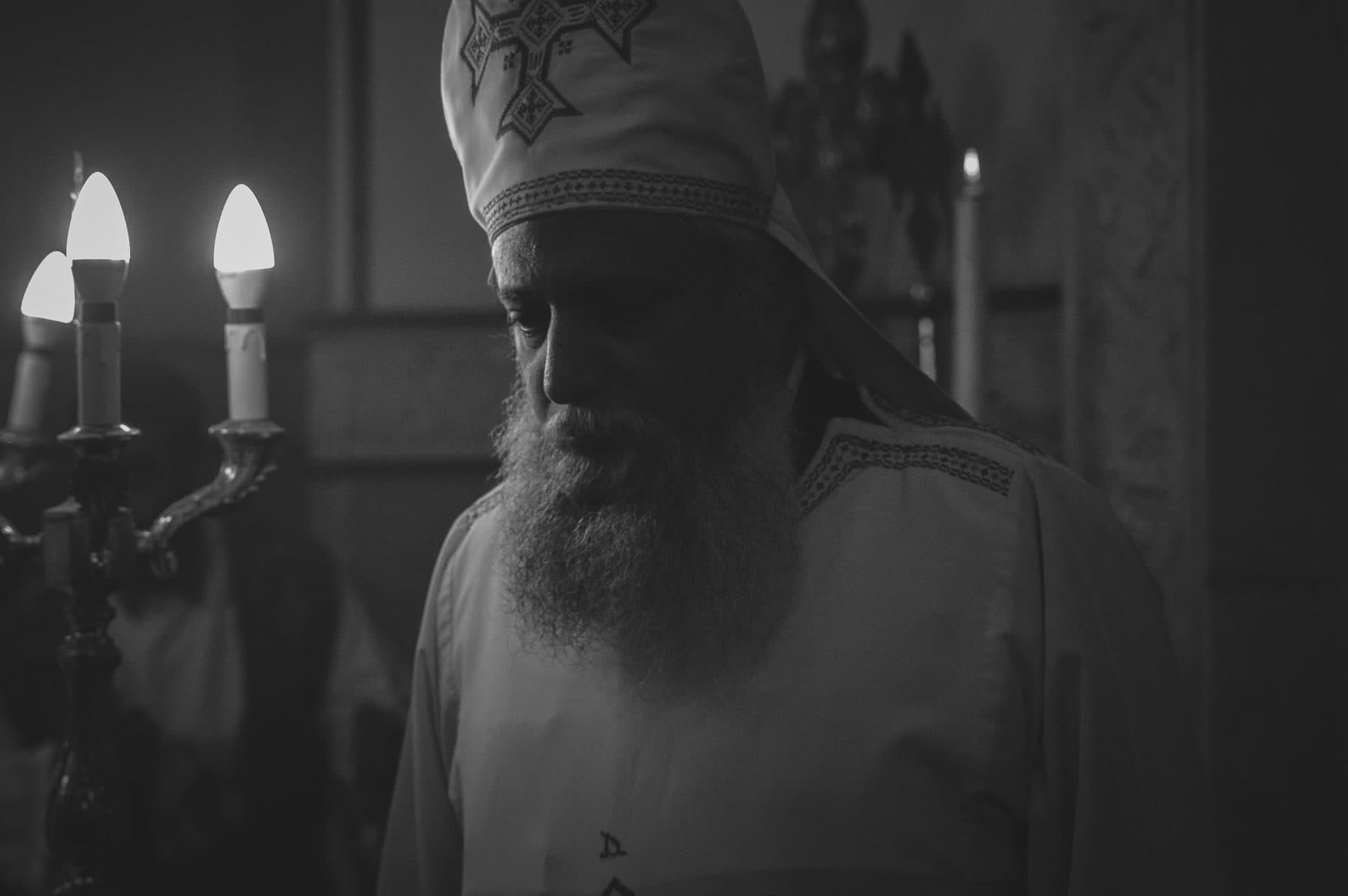 A Coptic priest at a candle-lit service in Cairo